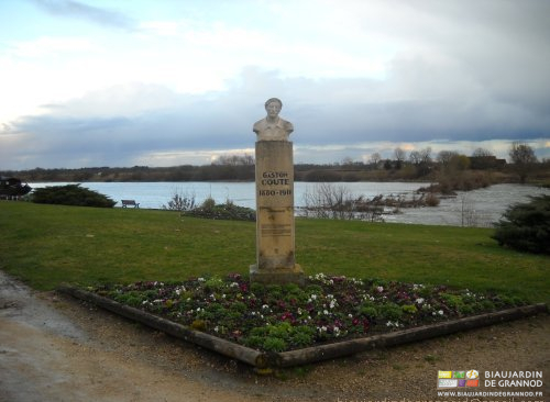 photo du buste de Gaston Couté dans un massif de fleurs en bord de Loire à Meung