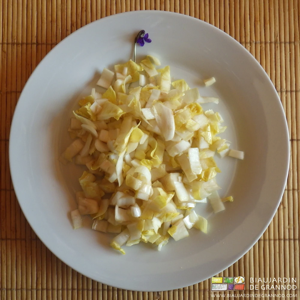 photo d'une assiette de salade d'endive avec fleur de violette
