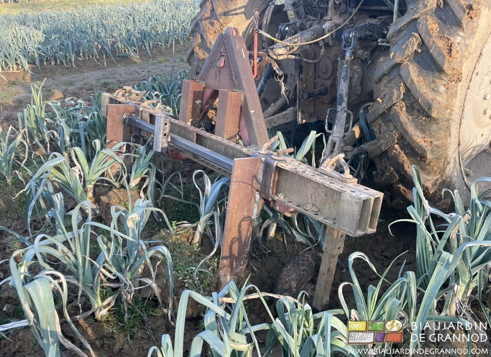 Photo de la barre porte outil équipée de lame souleveuse arrachant une planche de poireau