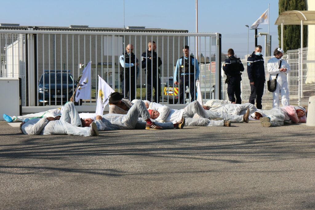 Photo de faucheurs volontaires couchés bloquant l’usine Basf Villefranche face aux gendarmes