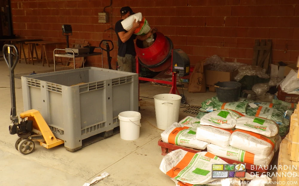 photo de Matthieu à la bétonnière mélangeant les nombreux sacs de semence d'engrais vert