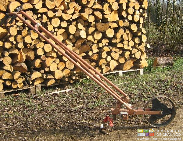 photo de notre houe rouge devant un tas de bois de chauffage