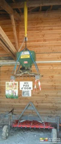 photo d'un semoir rangé suspendu à une ferme de charpente grâce à élingues et palan