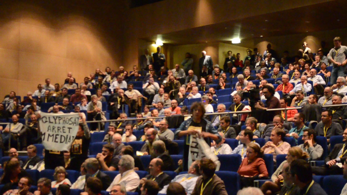 photo de 2 faucheurs déployant calmement leur banderole dans l'assistance