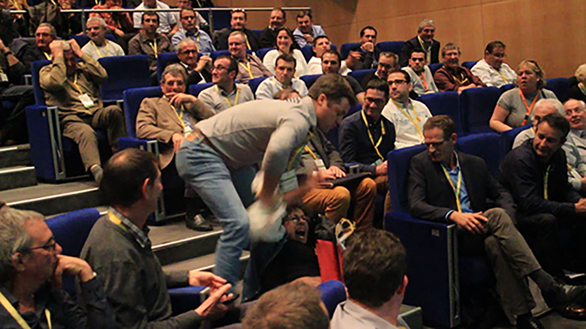 photo d'un viril agrochimiste tapant une faucheuse à terre sous les sourires des congressistes hommes et femmes