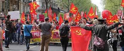 photo de mnifestation avec drapreaux rouges faucille et marteau