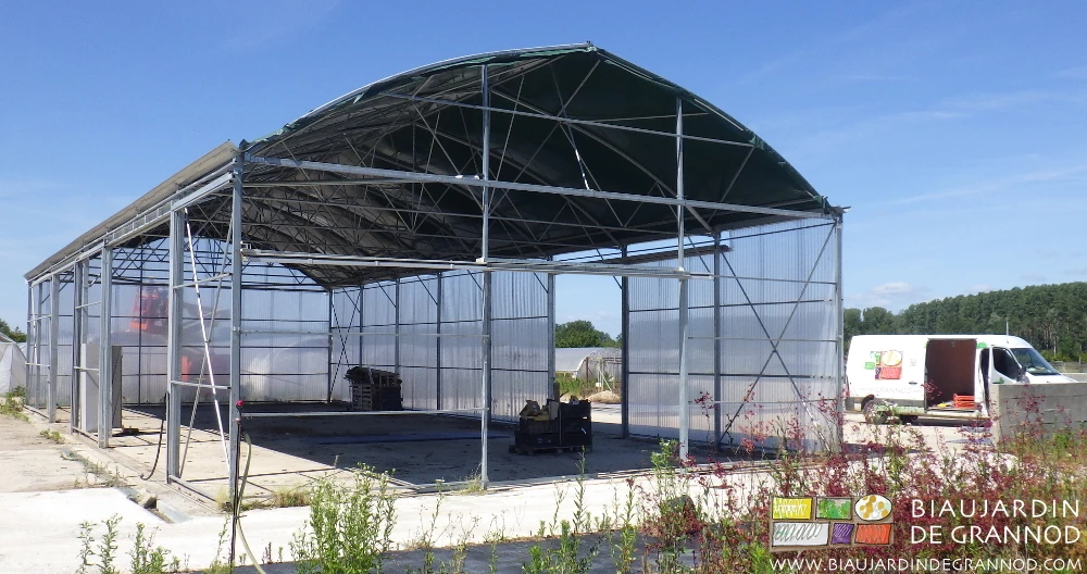 photo du bâtiment d'occasion couvert de film vert en cours de démontage