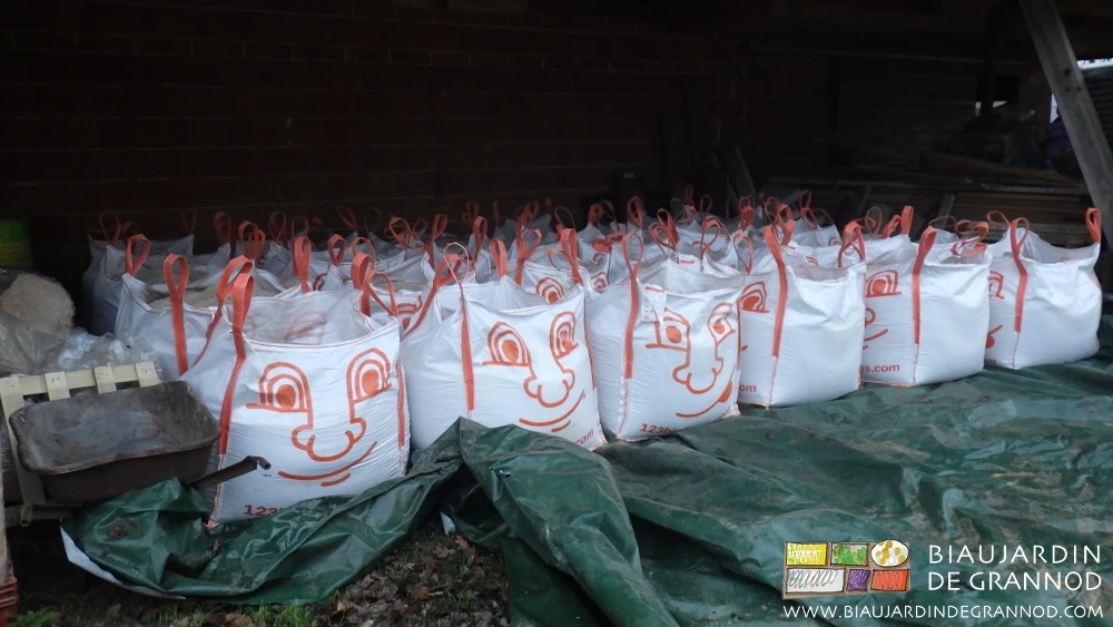 photo des big bag alignés à l'abri de la pluie sous l'auvent du bâtiment