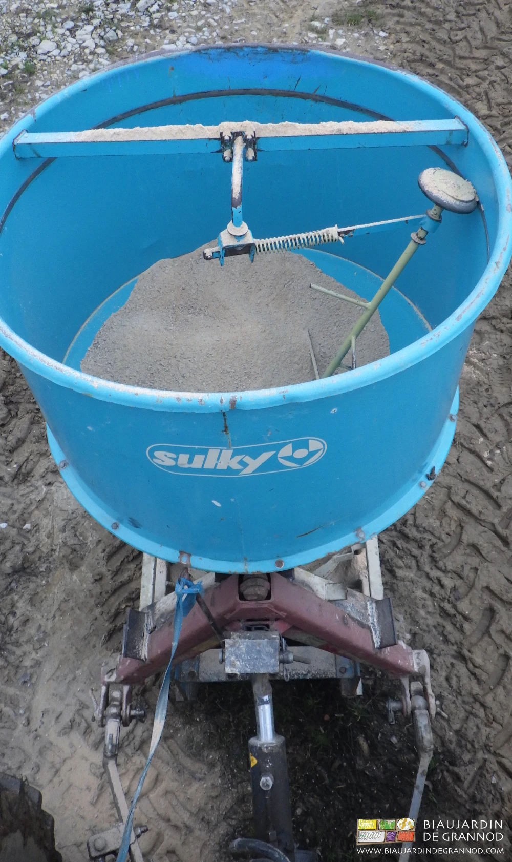 photo de l'épandeur à poudre de roche attelé au tracteur par son triangle rapide