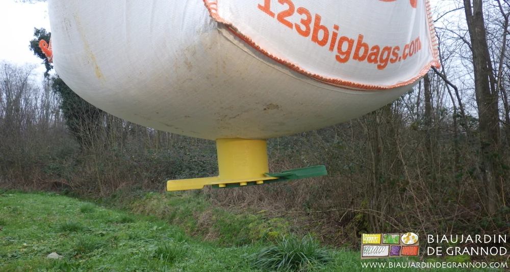 photo du big bag soulevé par les fourches, percé mais écoulement bloqué par la fermeture du cône