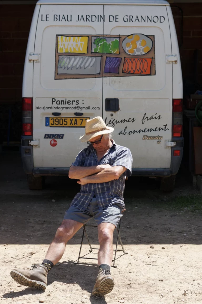 photo de Pascal en pleine sieste sur une chaise dans la cour devant son fourgon au GPL