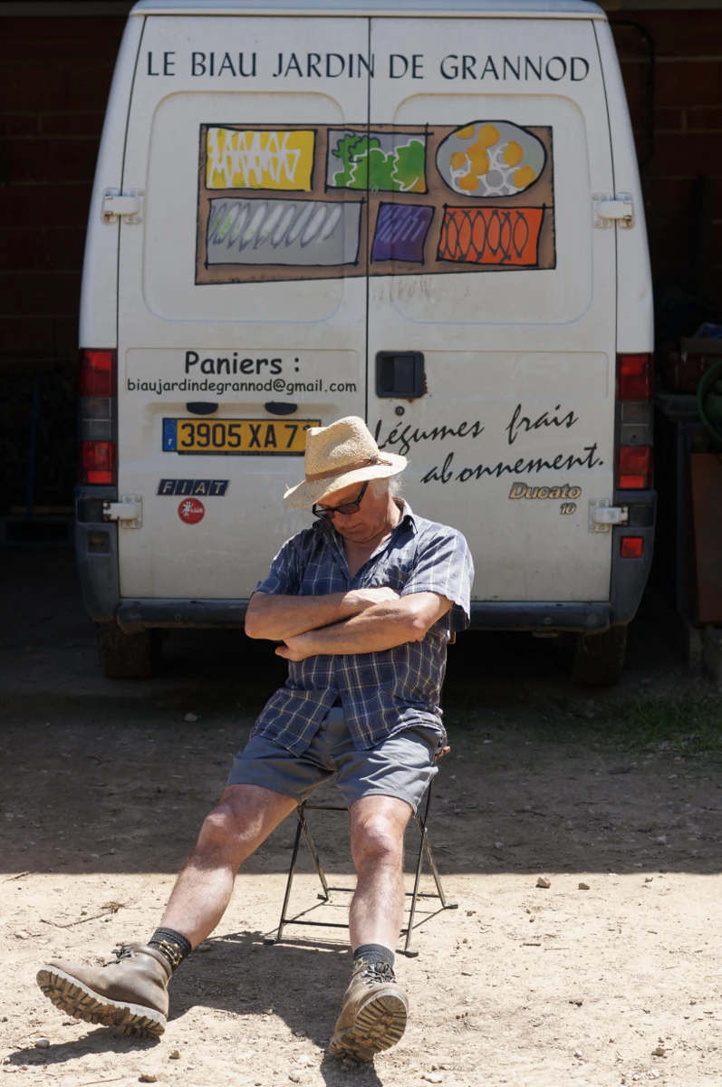 photo de Pascal en pleine sieste sur une chaise dans la cour devant son fourgon au GPL
