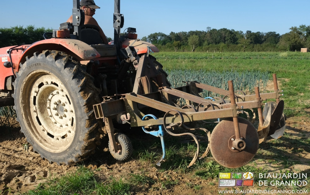 photo de Matthieu au tracteur ajustant la BPO pour butter les poireaux