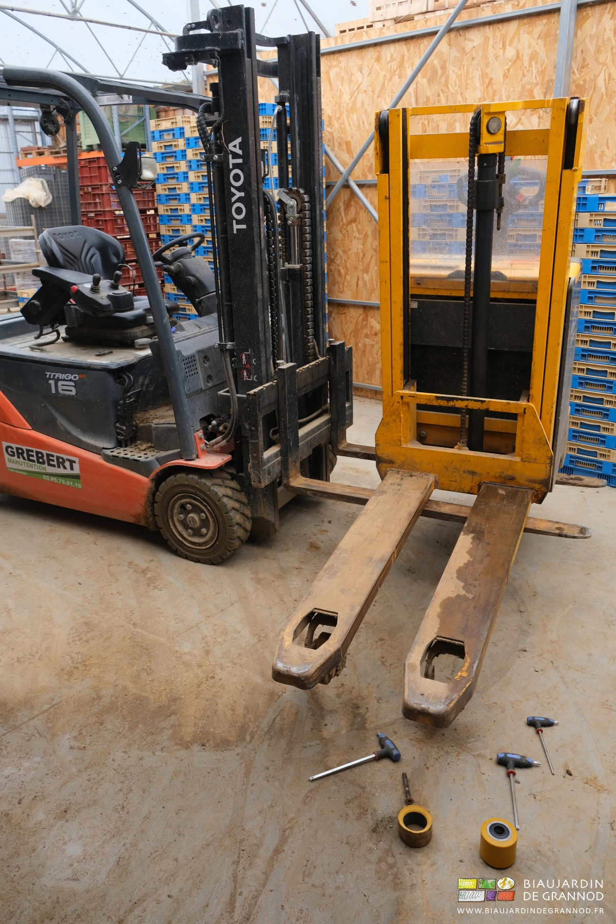 photo du remplacement d'une roulette du gerbeur levé par le chariot élévateur