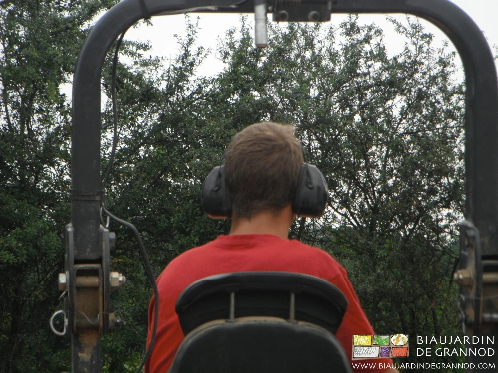 photo du Biau Jardinier les oreilles protégées par un casque pour utiliser l’arracheuse
