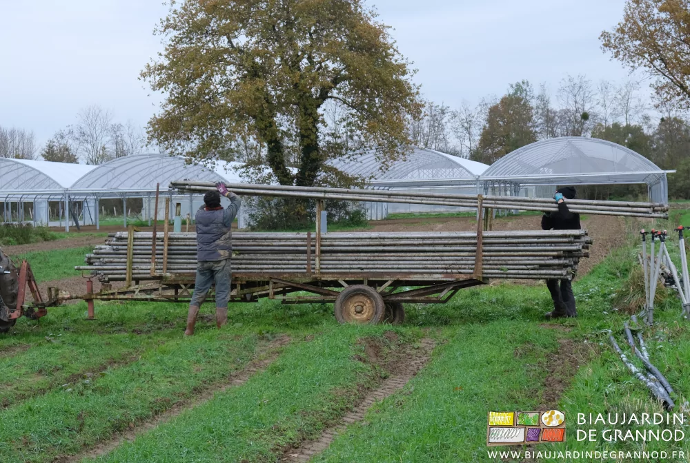 photo de Vivien et AZlicve empilant des tubes entre de hauts montants sur une remorque sans plancher
