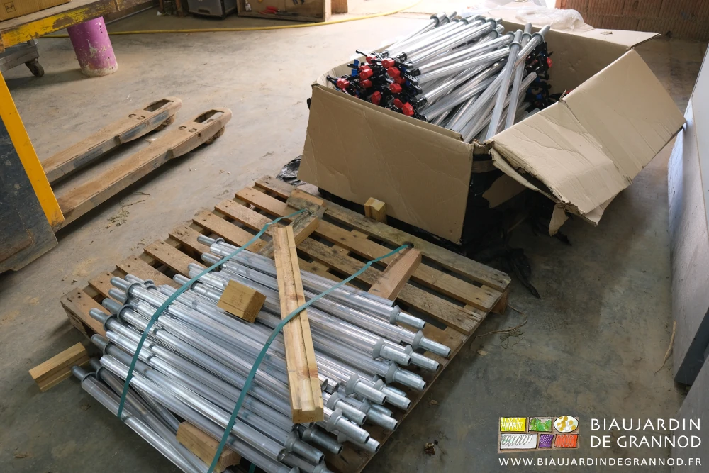 photo d'une palette de cannes neuves à coté d'un cartoon de cannes avec asperseur monté