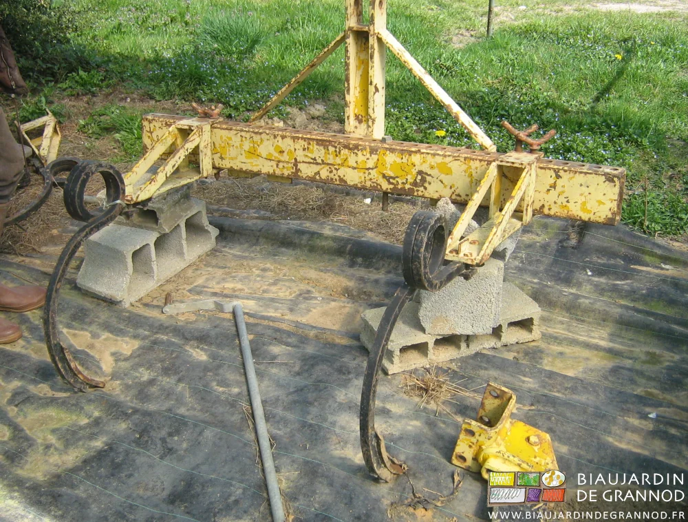 photo générale d'une barre jaune à 2 dents posée sur des moellons