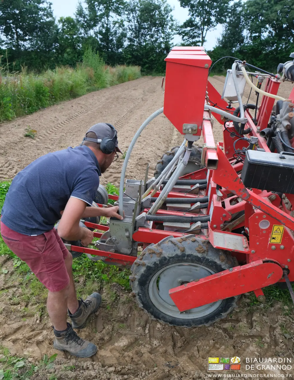 photo de Matthieu utilisant le tuyau raccordé au bol de stockage pour récupérer les graines non semées